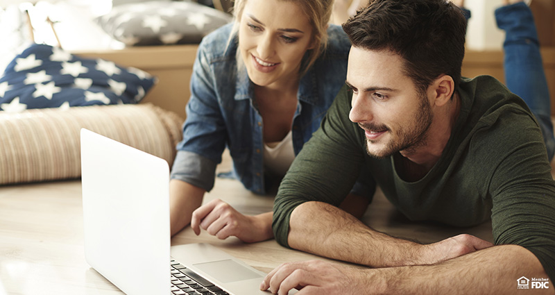 Young couple in new flat using laptop