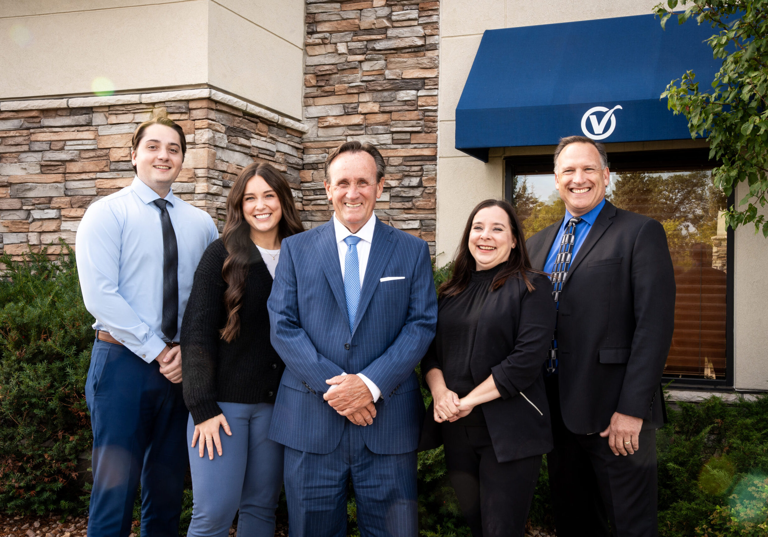 Group photo featuring Alex, Parker, Dan, Jenny, and Jeff outside of the bank