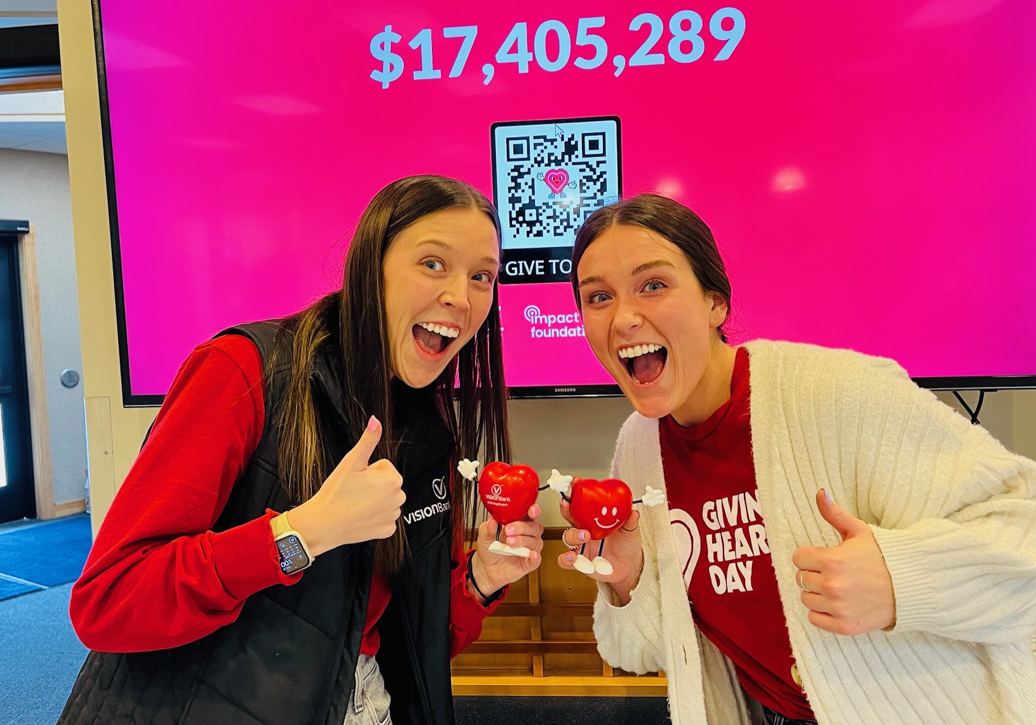 Team members Katelyn and Parker in front of the live giving hearts day donation tracker