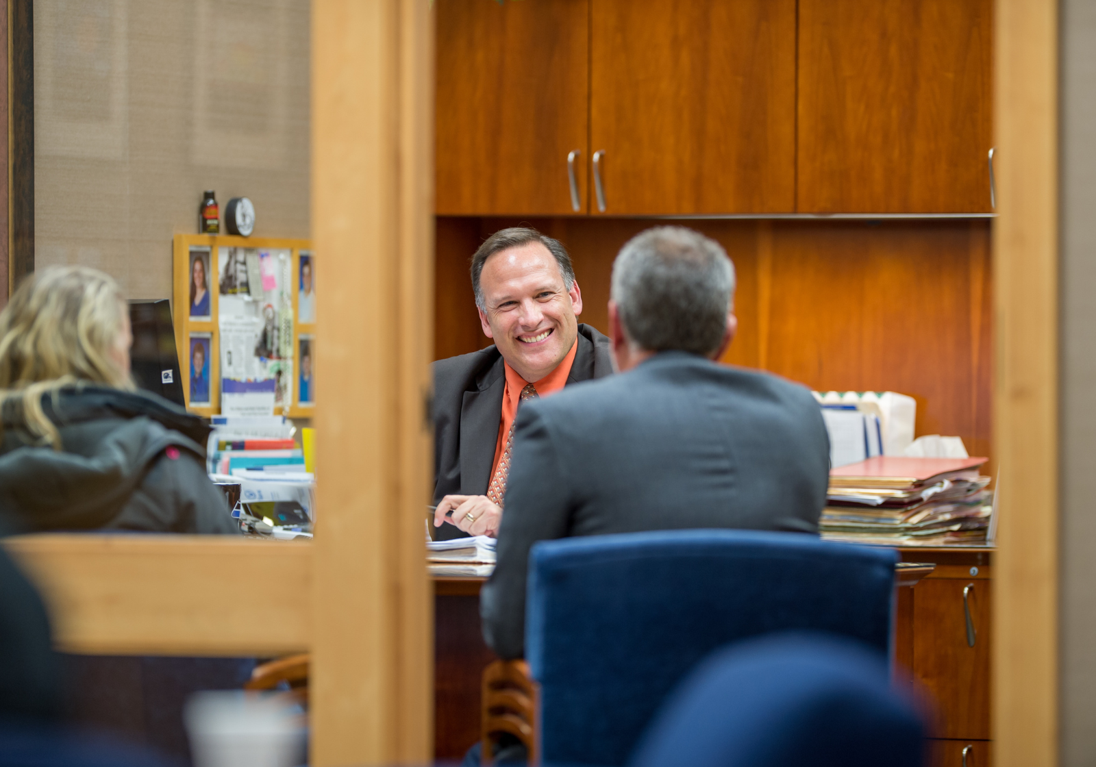 A banker talking with two customers in his office